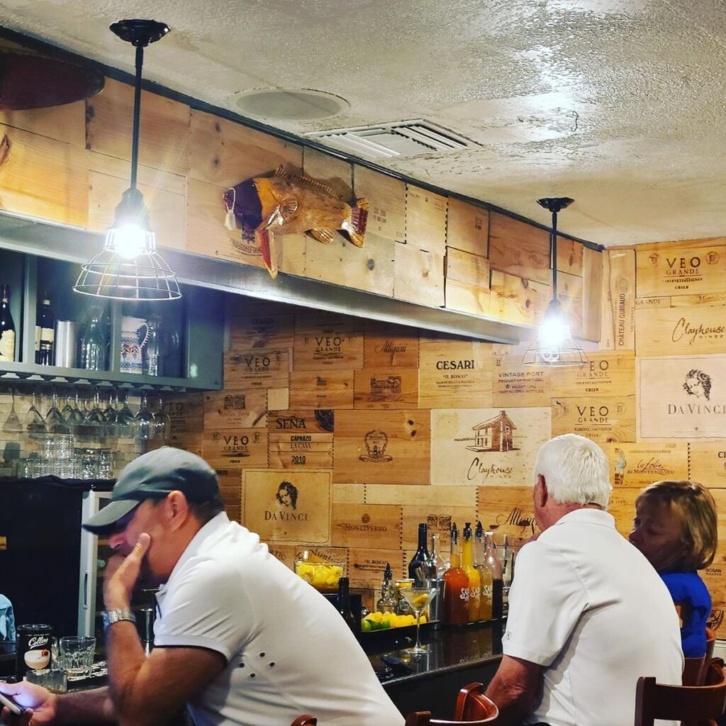 bar seating area with walls covered in wooden wine racks
