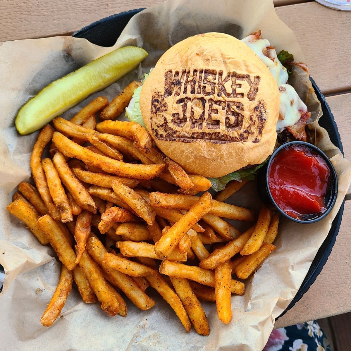 burger and fries with burger bun imprinted with restaurant logo Whiskey Joes